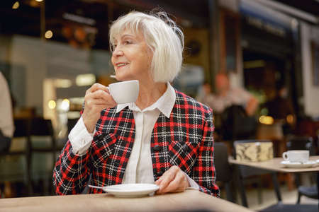 Good looking pensioner female relaxing at street cafeの写真素材