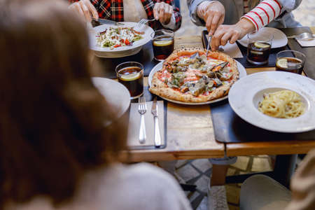 Friendly company enjoying delicious food in restaurantの写真素材