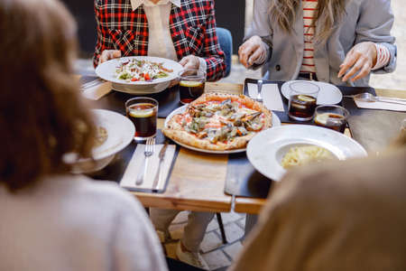 Friendly company enjoying delicious food in restaurantの写真素材