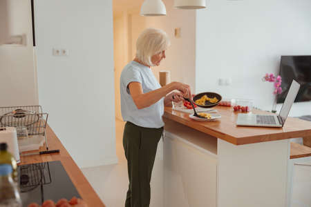 Senior woman having healthy breakfast at homeの写真素材