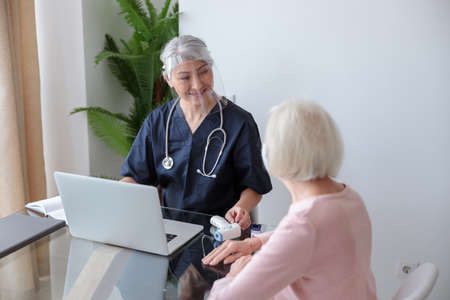 Medical specialist appointment eldery female in her apartmentの写真素材