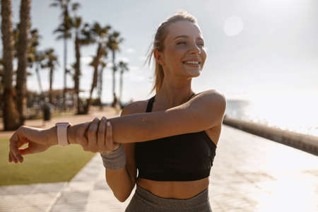 Beautiful athletic woman relaxing outdoors in morningの写真素材