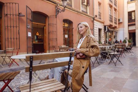 Full length photo of pensive lady sitting at street restaurant tableの写真素材