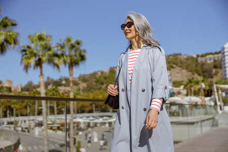 Urban lady strolling in modern outfit on city streetの写真素材