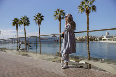 Elegant mature lady standing outdoors by seafrontの写真素材