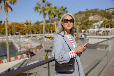 Elegant Asian lady standing outdoors in cityの写真素材