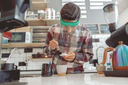 Portrait of focused barista drawing pattern on milk foamの写真素材