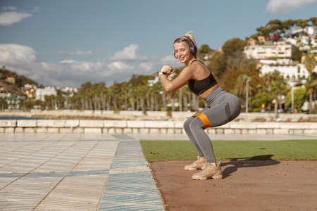 Cheerful woman exercising with elastic band outdoorsの写真素材
