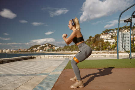 Cheerful woman training with elastic band outdoorsの写真素材