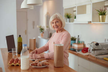 Senior woman cooking in kitchen at homeの写真素材