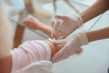 Nurse giving injection to senior woman in living roomの写真素材
