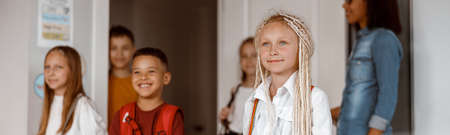 Happy children standing in class at schoolの写真素材