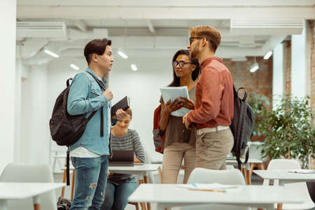 Students with backpacks standing and holding notebooksの写真素材