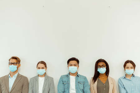 Business people standing on the white wall backgroundの写真素材