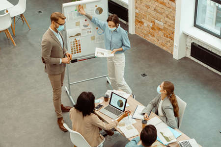 Two colleagues standing near flipchart in the office