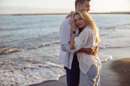 Portrait of relaxed man and lady enjoying sunset by the seaの写真素材
