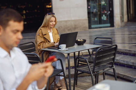 Focused woman is working on laptop outsideの写真素材