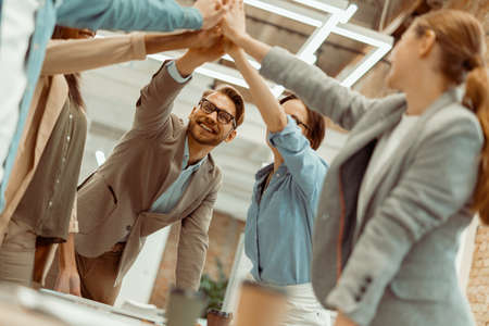 Business people giving five to their colleague in the office