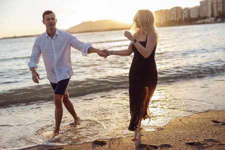 Carefree couple enjoying evening on beach togetherの写真素材