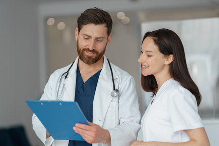 Two doctor colleagues discussing patient diagnosis stand in clinic hallの写真素材