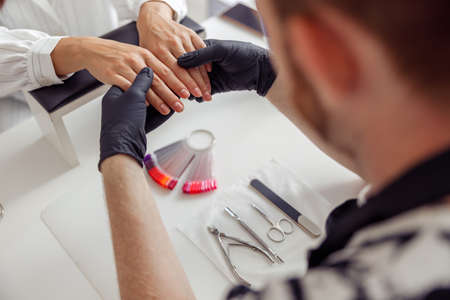 Nail master working on client nails at beauty centerの写真素材