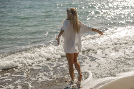 Back view of inspired woman enjoying vacation on the seashore aloneの写真素材