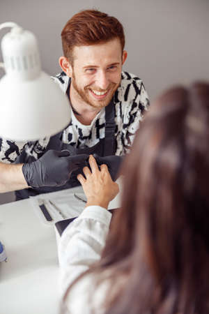 Experienced nail technician working in modern manicure salonの写真素材