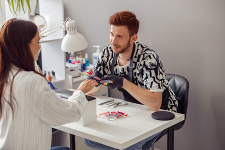 Manicure specialist providing nail service for client in salonの写真素材