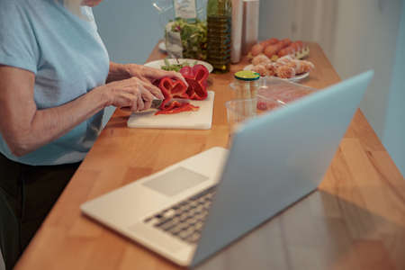 Photo of aged lady making breakfast at homeの写真素材