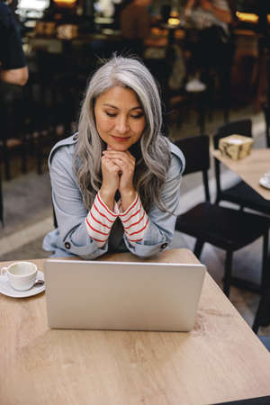 Long haired lady browsing internet at cafeの写真素材