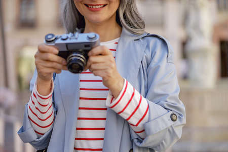 Well dressed woman browsing camera pictures outdoorsの写真素材