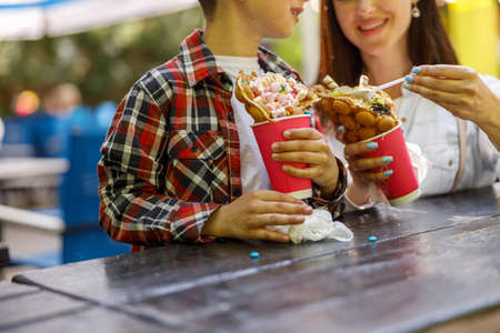Sweet waffles with ice cream in hands of small boy and mother. Weekend in summer concept.の写真素材