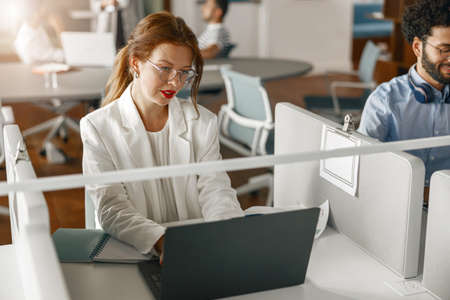 Group of diverse coworkers analyzing sales report while working together in the office