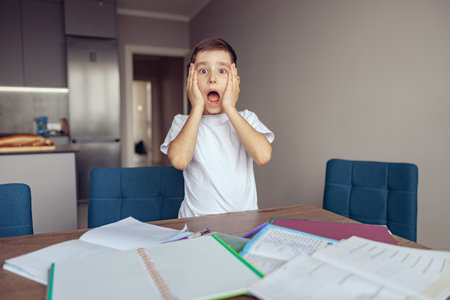 Funny scared small boy expressing shocked emotions about lessons. Scary homework.の写真素材