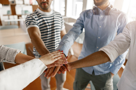 Close up of group of multi ethnic coworkers stacked hands together as concept of corporate unityの写真素材