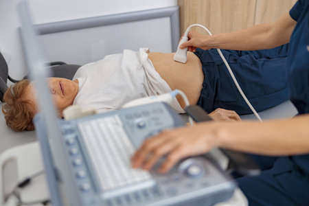 Close up of doctor ultrasound examine senior patient abdomen at hospital. Prenatal diagnosis center