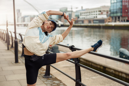 Beautiful sportive woman doing stretching exercise before running in the cityの写真素材