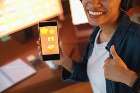 Woman graphic designer is showing smartphone during work day in home office