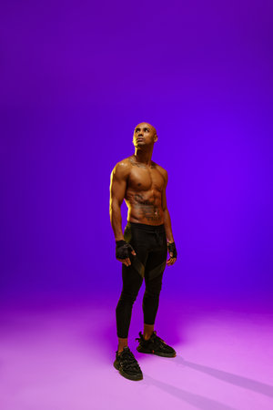 Sporty man with muscled naked body on white studio background with color filter looking at sideの写真素材