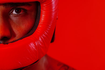 Close up of sporty man wearing protective head guard for boxing on studio backgroundの写真素材