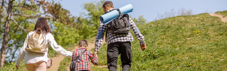 Rear on family of travelers with small son. Trekking of kid with parents. Hiking.