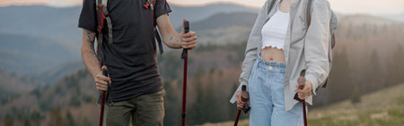 Close up of male and female legs in trekking shoes with waling sticks in hands. Travelers.の写真素材