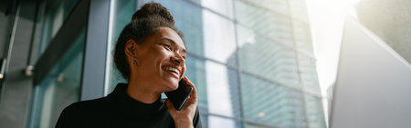 Smiling woman talking on phone with client sitting in cafe near window. Distance work conceptの写真素材