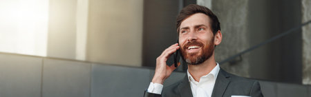 Smiling office worker in suit standing on stairs and drinking coffee during break near office