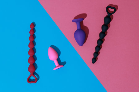 Top view of buttplugs and dildos for anal sex on colored background with shadows. Sex shop conceptの写真素材