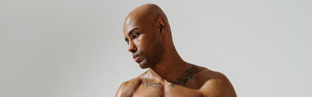 Portrait of sporty man with muscled naked body on white studio background and looking at side