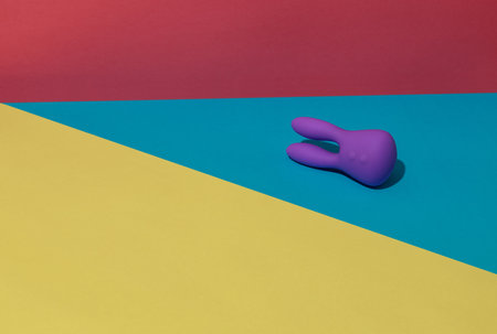 Violet dildo vibrator for clitoris on colored background with contrast shadows. Sex toy for adultの写真素材