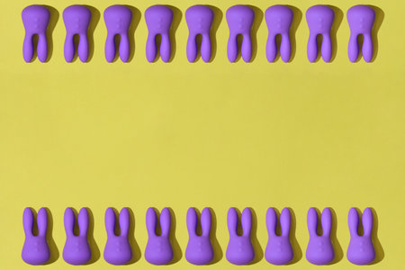 Top view of many violet dildo vibrators for clitoris on yellow background. Sex toys for adultの写真素材