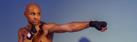 Professional kickboxer is training and practicing punch on studio background with shadowsの写真素材
