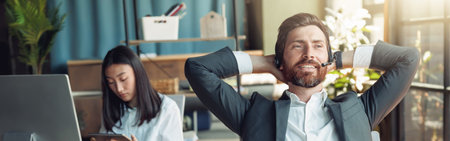 Man office worker have a rest on his workplace on background of colleagueの写真素材